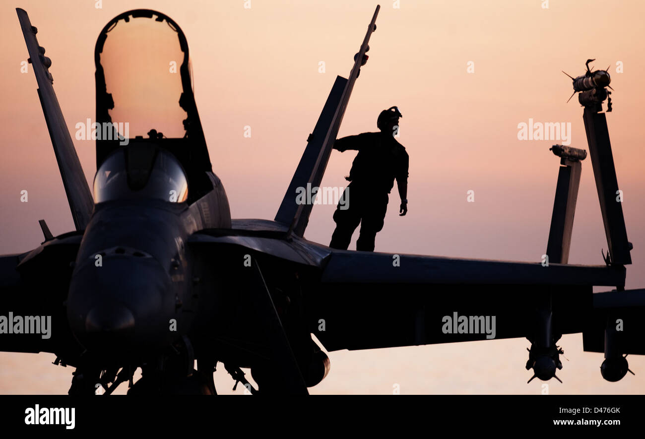 Un capitano di aereo a bordo della USS Carl Vinson conduce un'ispezione pre-volo di un F/A-18C Hornet, garantendo la prontezza operativa dell'aereo prima di una missione. Foto Stock