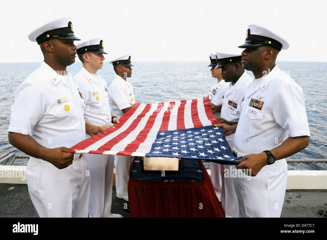 I marinai preparare una bandiera per la sepoltura in mare a bordo della USS Dwight D. Eisenhower Foto Stock