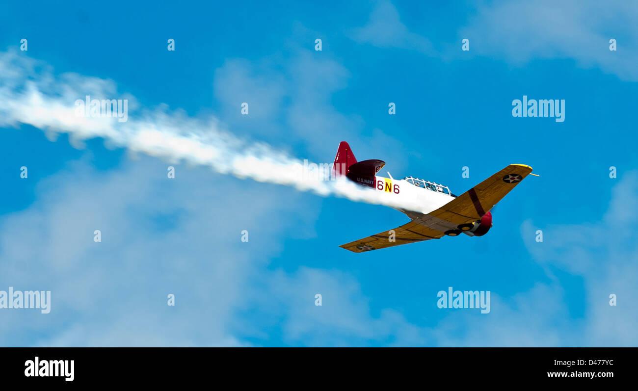 Un pilota professionista vola un aereo d'epoca su veterani a Ford Island a Pearl Harbor, rendendo omaggio al loro servizio e commemorando la loro eredità. Il volo rappresenta un collegamento tra la storia dell'aviazione militare e i membri di servizio moderni. Foto Stock