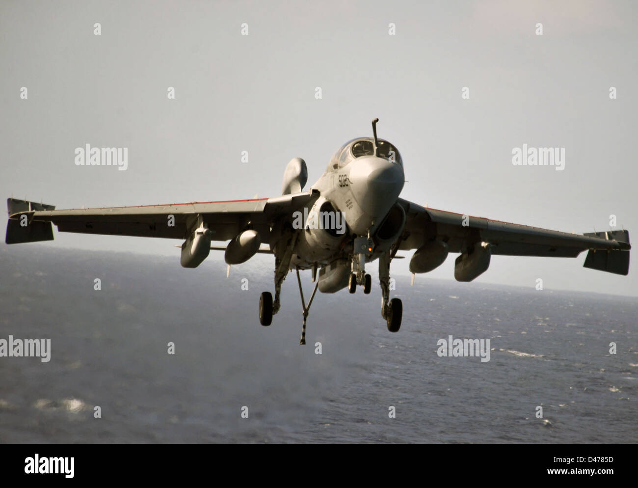 Un jet si avvicina alla cabina di pilotaggio della USS Abraham Lincoln (CVN 72), preparandosi per l'atterraggio durante un'esercitazione militare in mare, mostrando operazioni basate su vettori. Foto Stock
