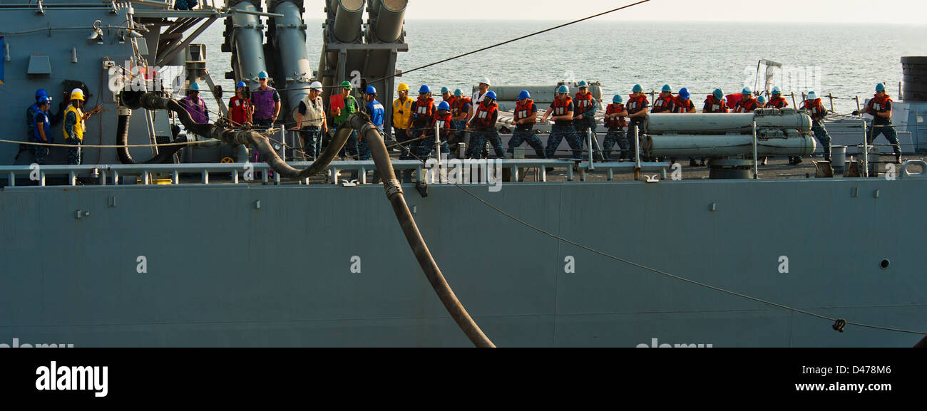 I marinai a bordo della USS John Paul Jones (DDG 53) gestiscono un'operazione di rifornimento in mare, tirando un tubo di rifornimento a sonda singola per rifornire la nave mentre era in servizio nel Mar Arabico. Foto Stock