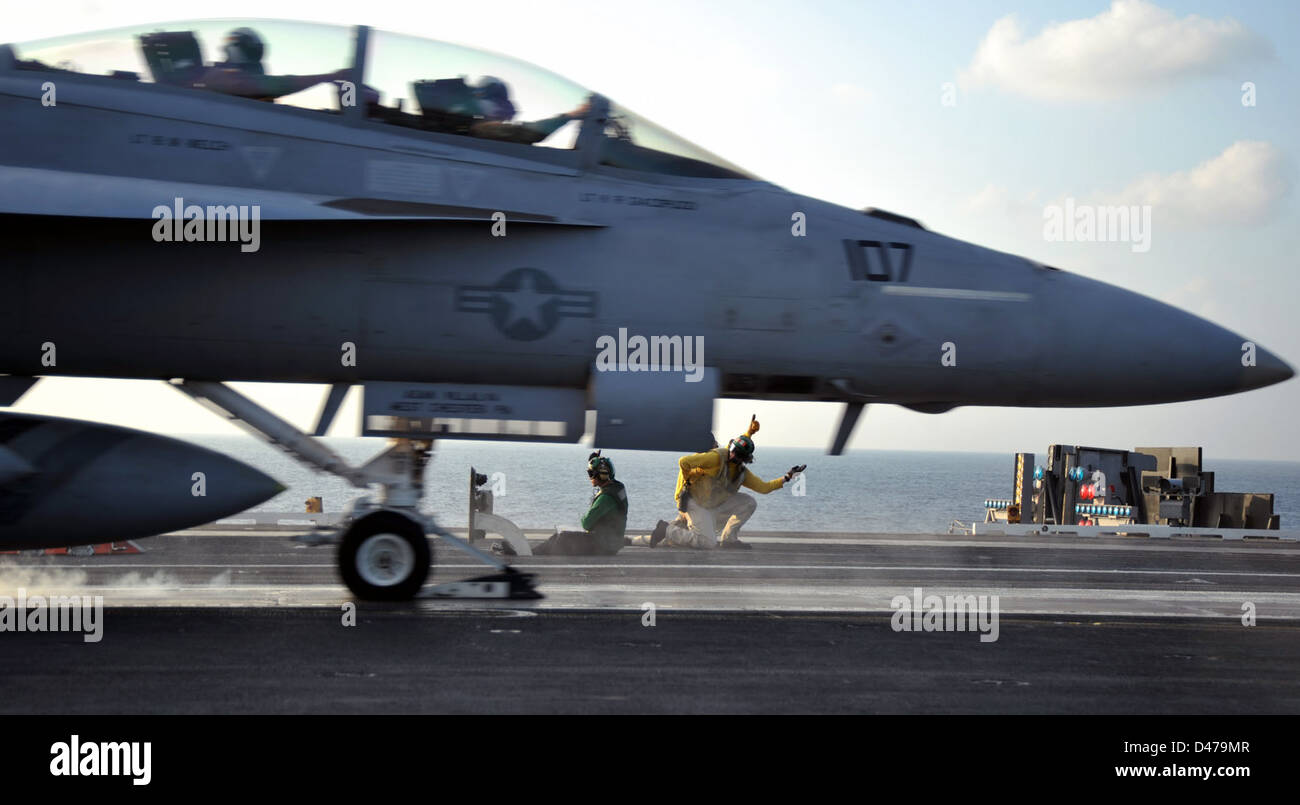 I marinai a bordo della USS Abraham Lincoln (CVN 72) lanciano un jet dalla cabina di pilotaggio della portaerei durante una missione nell'Oceano Indiano, dimostrando capacità di aviazione navale. Foto Stock