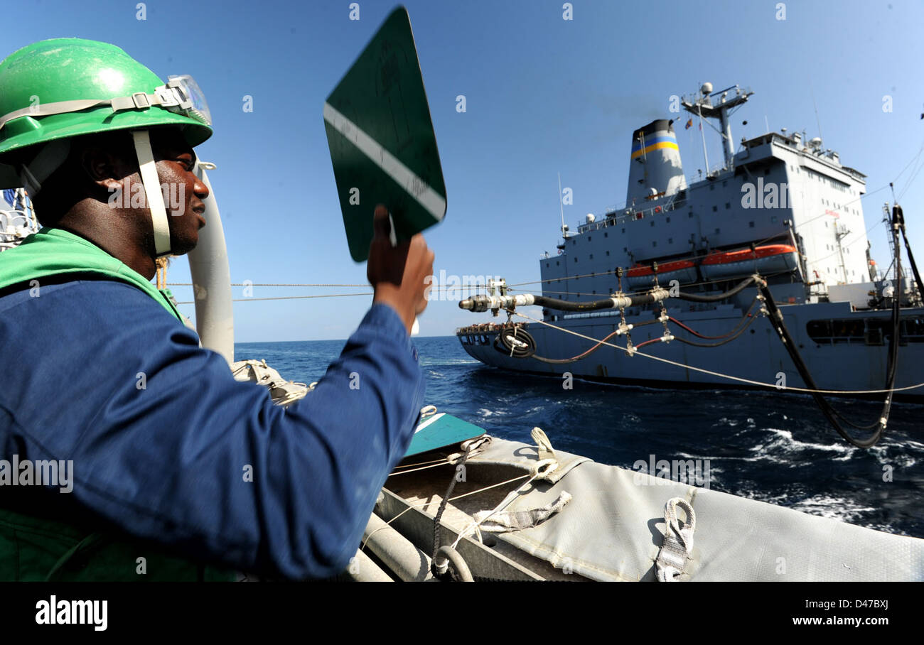 Un marinaio della Marina degli Stati Uniti a bordo della USS Halsey (DDG 97) segnala alla USNS Guadalupe durante un'operazione di rifornimento in mare nel Mar Arabico, sostenendo la logistica per le operazioni militari. Foto Stock
