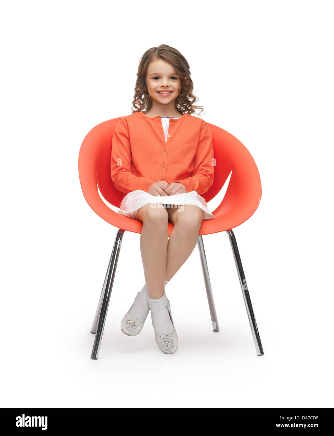 Pre-teen ragazza in abiti casual seduti su una sedia Foto Stock