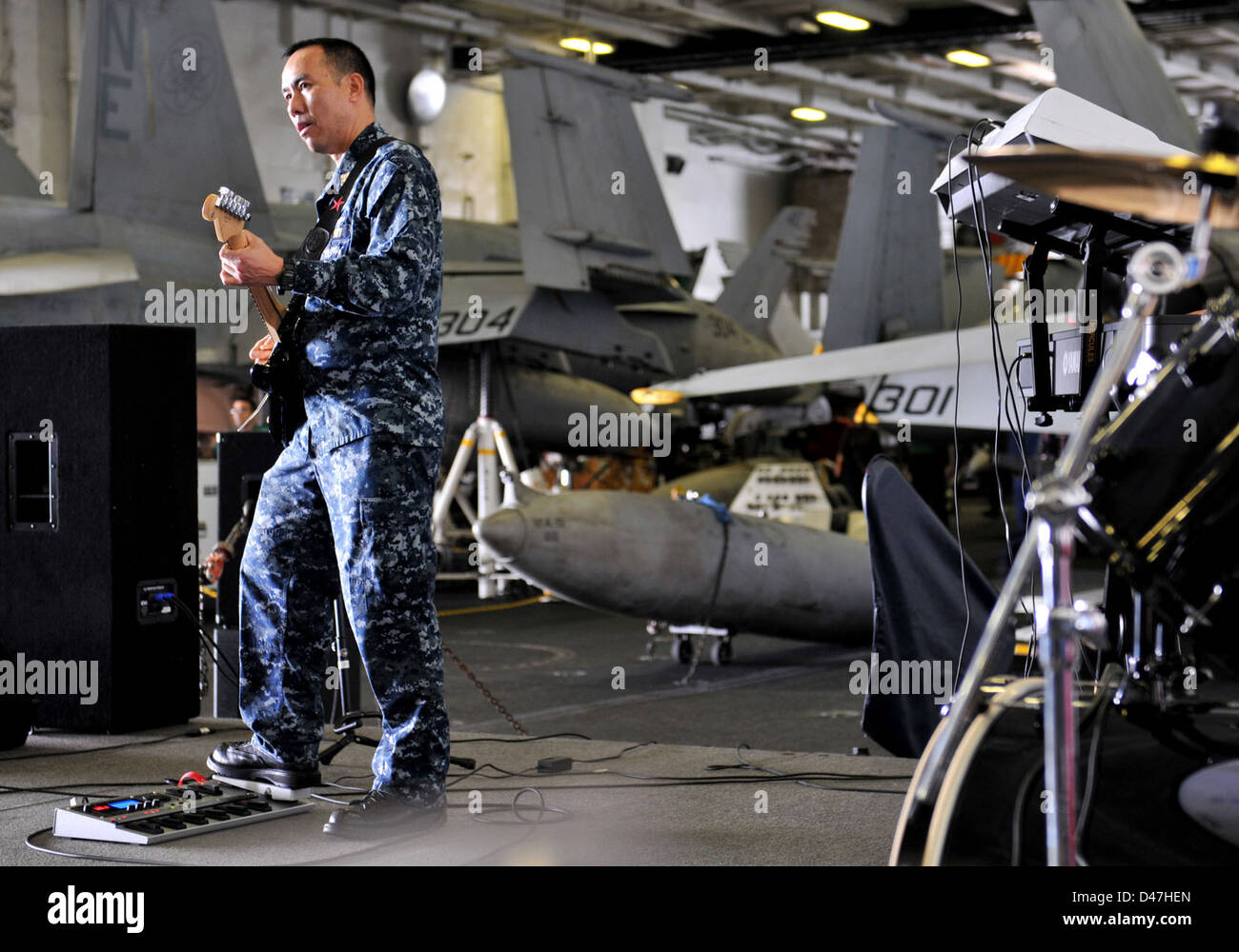 Il capo Joselito Tolentino della banda della nave della USS Abraham Lincoln controlla la sua chitarra nel Mar Arabico. Tolentino, specialista della logistica, fa parte del team musicale della portaerei classe Nimitz. Foto Stock