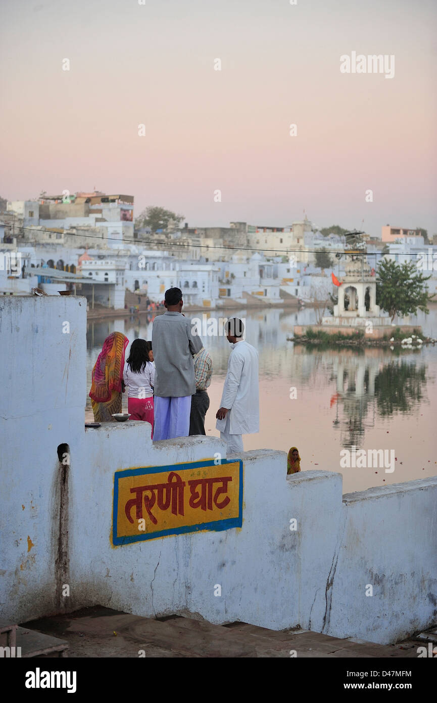 Una famiglia indiana guardare il tramonto al lago di santa di Pushkar; Rajasthan, India. Foto Stock