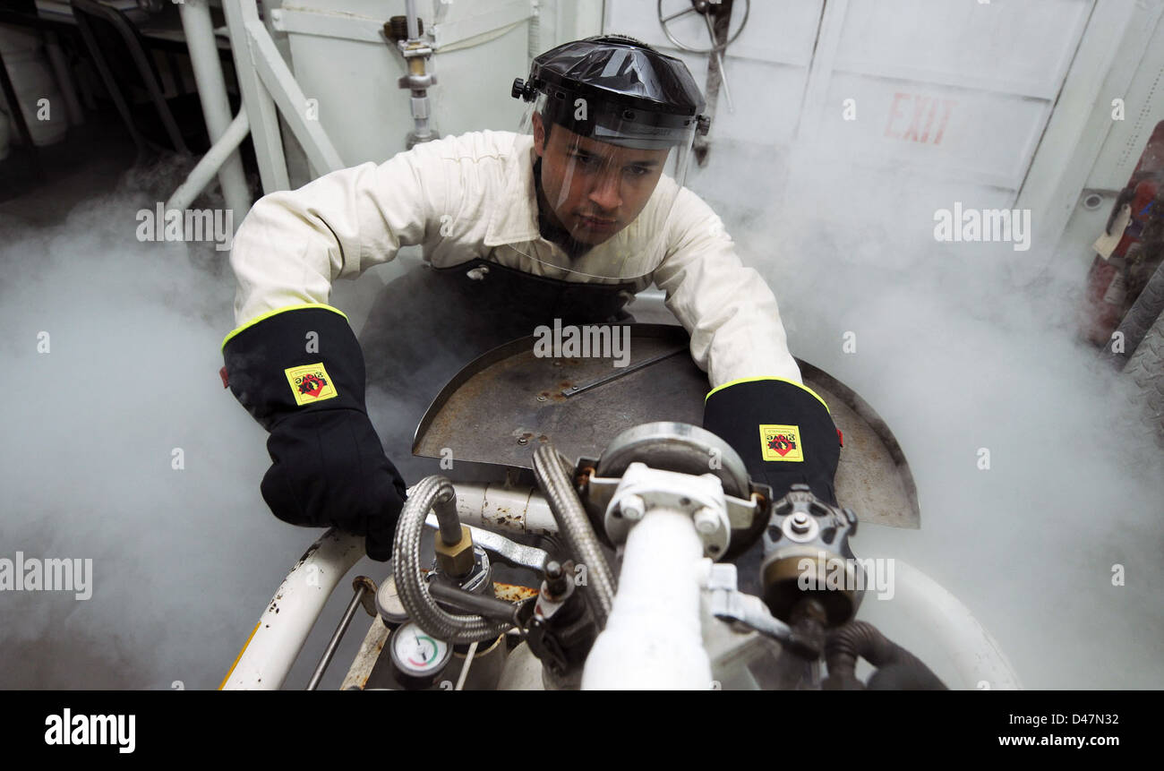 Engineman Fireman Christian Martinez esegue la manutenzione serrando un raccordo del manometro su un carrello per ossigeno liquido TMU-70 a bordo della USS Abraham Lincoln (CVN 72), garantendo la prontezza operativa delle attrezzature critiche sulla portaerei. Foto Stock