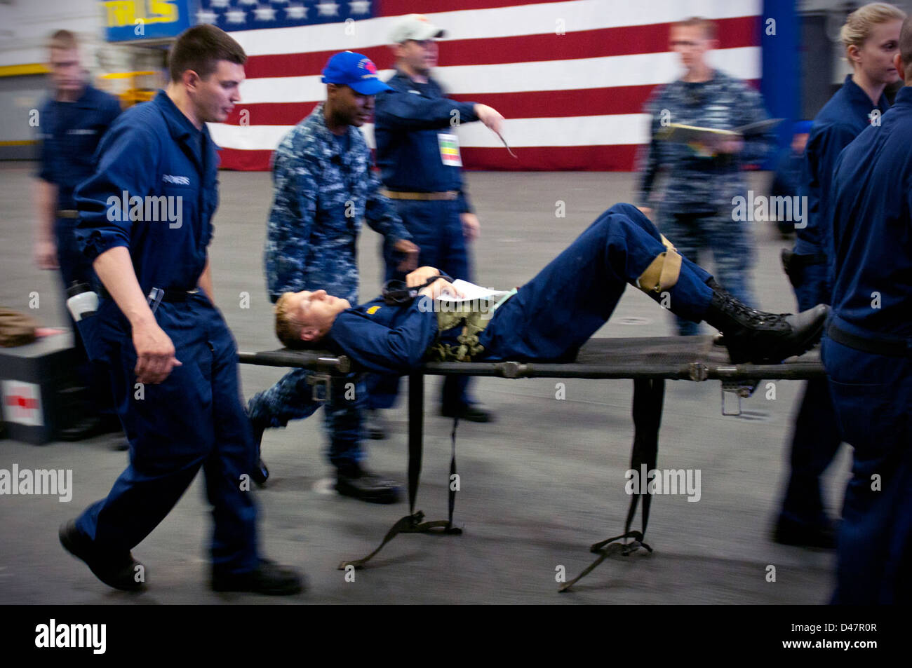 I marinai utilizzano una barella per il trasporto di un guardiamarina dall'U.S. Accademia navale durante una massa casualty trapano. Foto Stock