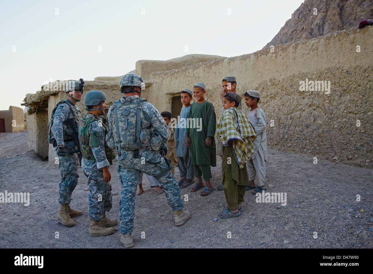 A Kandahar, Afghanistan - Maggio 14, 2020: i soldati USA intrattenere un gruppo di bambini afghani durante una pattuglia. Foto Stock