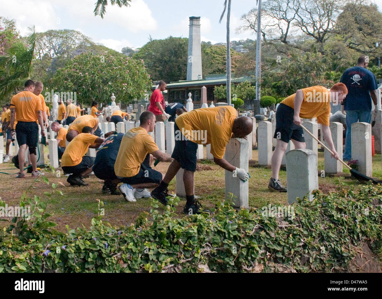 I marinai partecipano a un progetto di relazioni con la comunità per pulire e mantenere le tombe dei membri caduti di servizio in un cimitero di Oahu in onore del Memorial Day. Questo sforzo riflette l'impegno della Marina degli Stati Uniti a onorare il servizio e il sacrificio dei veterani militari. Foto Stock