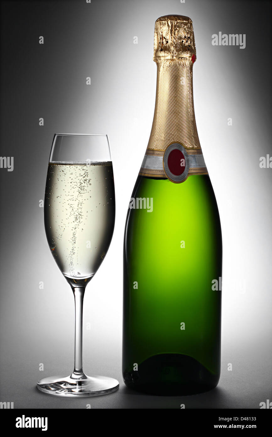 Bottiglia di champagne e vetro in Spotlight Foto Stock