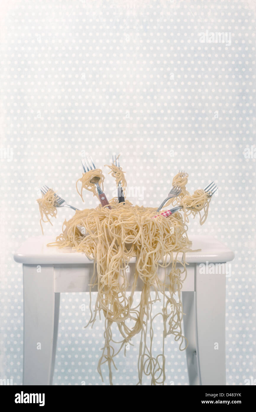 Una piastra piena di spaghetti con cinque forcelle Foto Stock