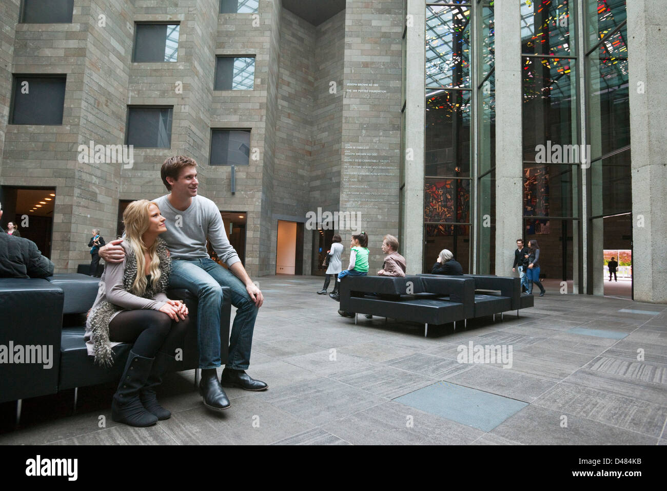 Giovane seduto nel foyer del National Gallery of Victoria. Melbourne, Victoria, Australia Foto Stock