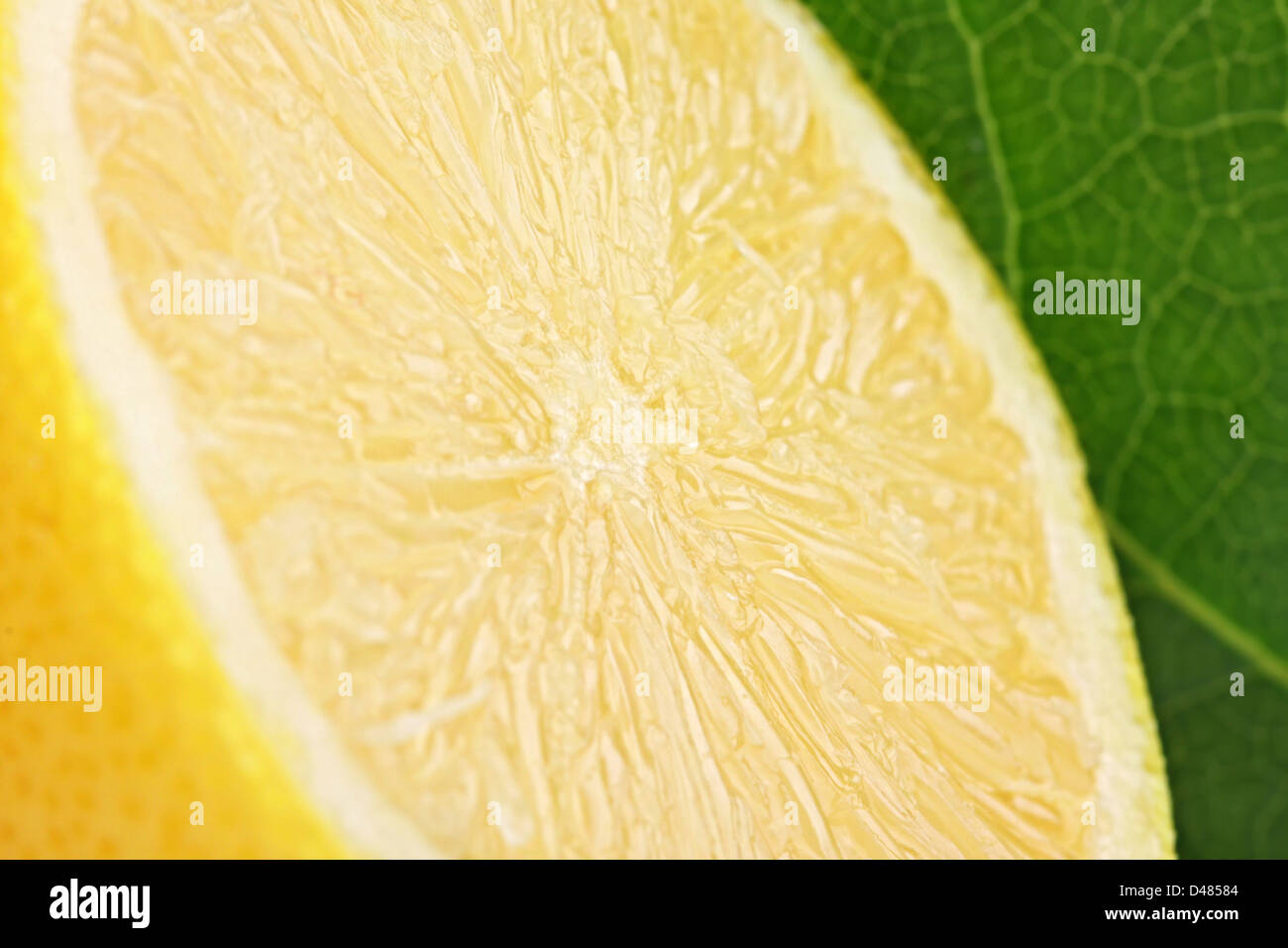 Un dolce limone tagliato con una foglia verde in backgrond. Foto Stock