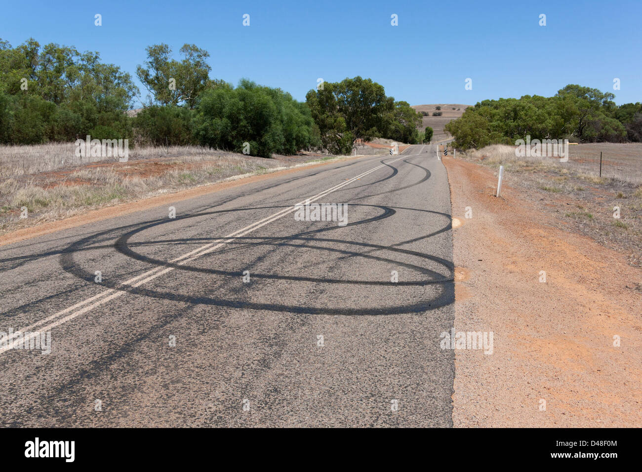 Burn Out auto tracce di pneumatici sulla strada da spiinning ruote, Murchison Australia Occidentale Foto Stock