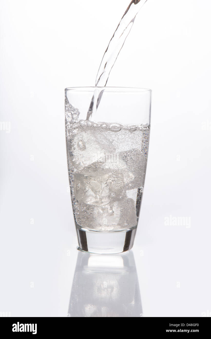 Acqua frizzante versando in vetro Foto Stock