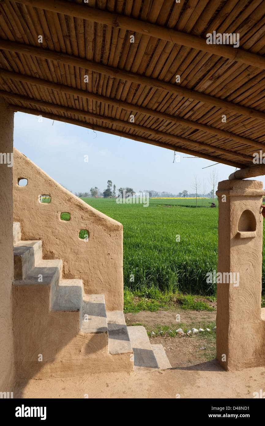 Il paesaggio agricolo vista dalla veranda di un tradizionale edificio di fango nello stato indiano del Punjab. Foto Stock