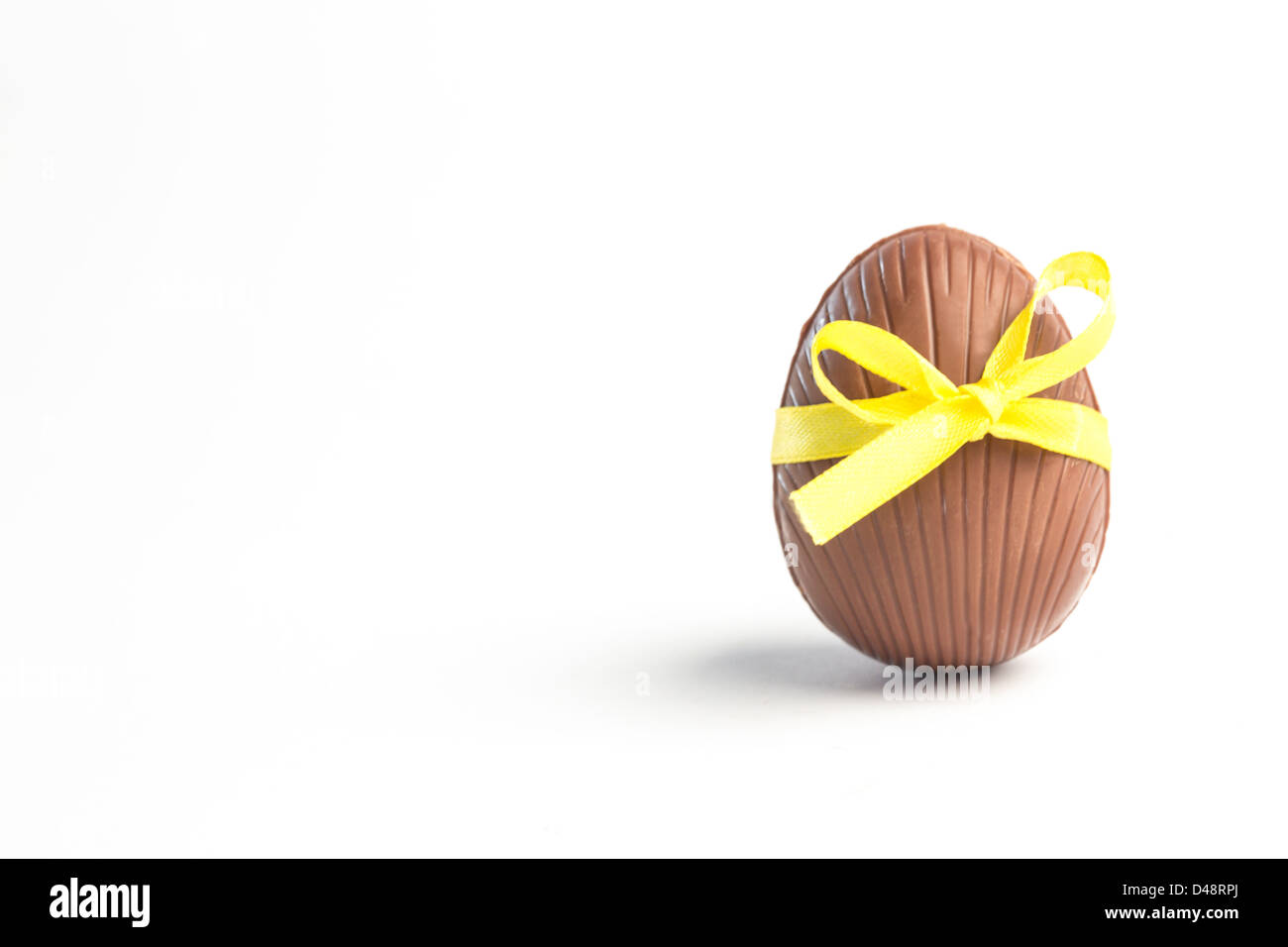 Il cioccolato uovo di pasqua in un nastro giallo Foto Stock