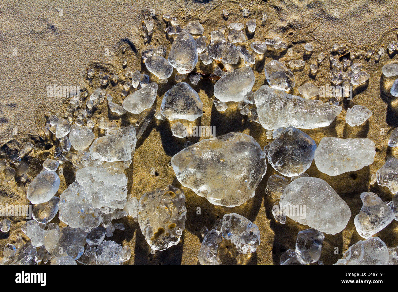 Ghiaccio cristallino pietre sulla spiaggia sabbiosa del Mar Baltico, Foto Stock