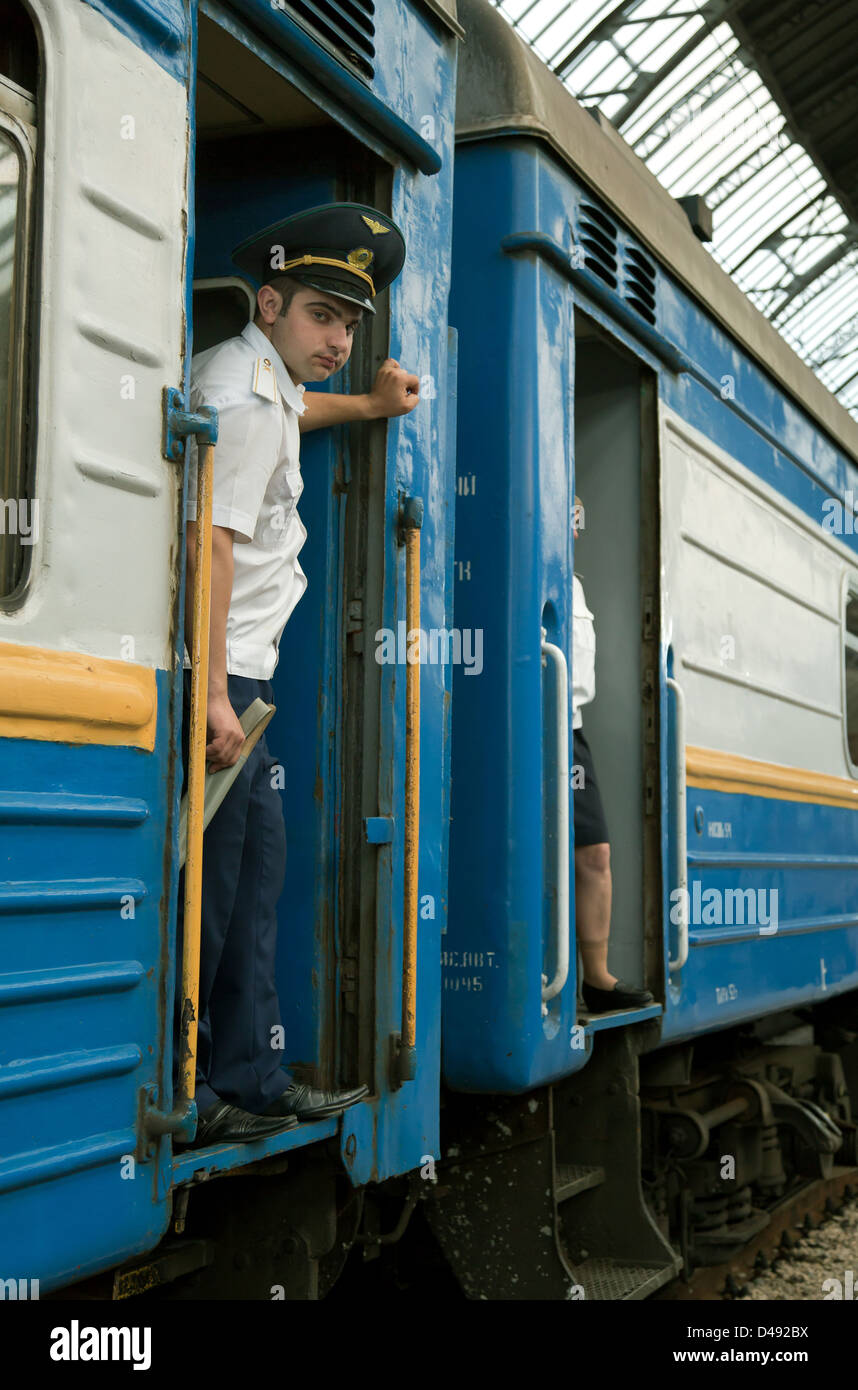 Lviv, Ucraina, Schaffner nella porta di un treno in partenza presso la stazione principale Foto Stock