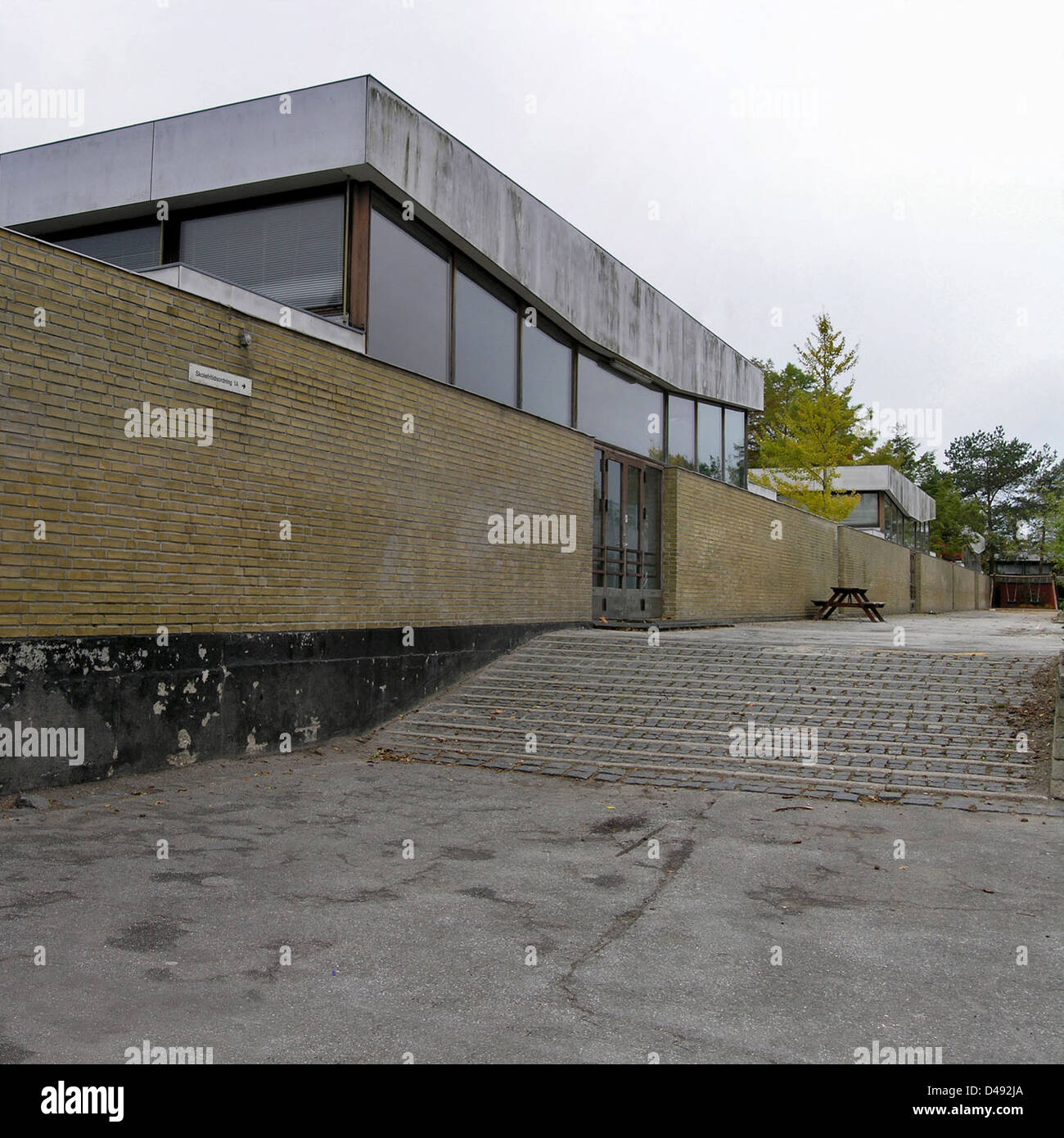 La Nyager School di Rødovre, Copenaghen, progettata da Arne Jacobsen tra il 1959 e il 1964, è un esempio di architettura modernista scandinava. L'edificio presenta un design funzionale con un'attenzione particolare alla luce e all'apertura, riflettendo il caratteristico stile minimalista e pratico di Jacobsen. Si integra perfettamente con l'ambiente circostante, offrendo un'estetica pulita e moderna. Foto Stock