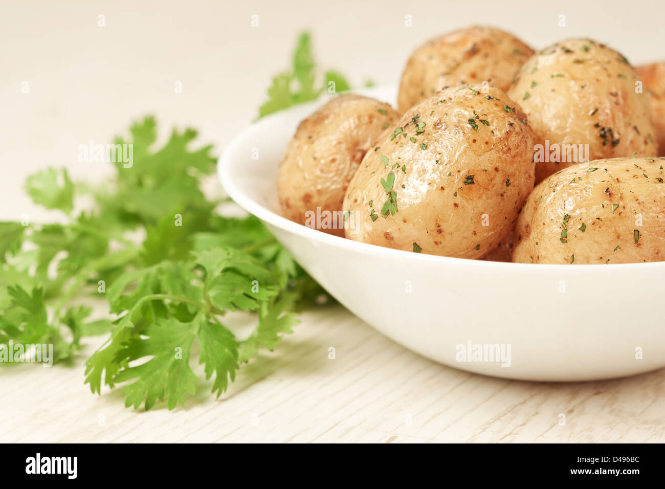 Patate arrosto con prezzemolo nel recipiente Foto Stock