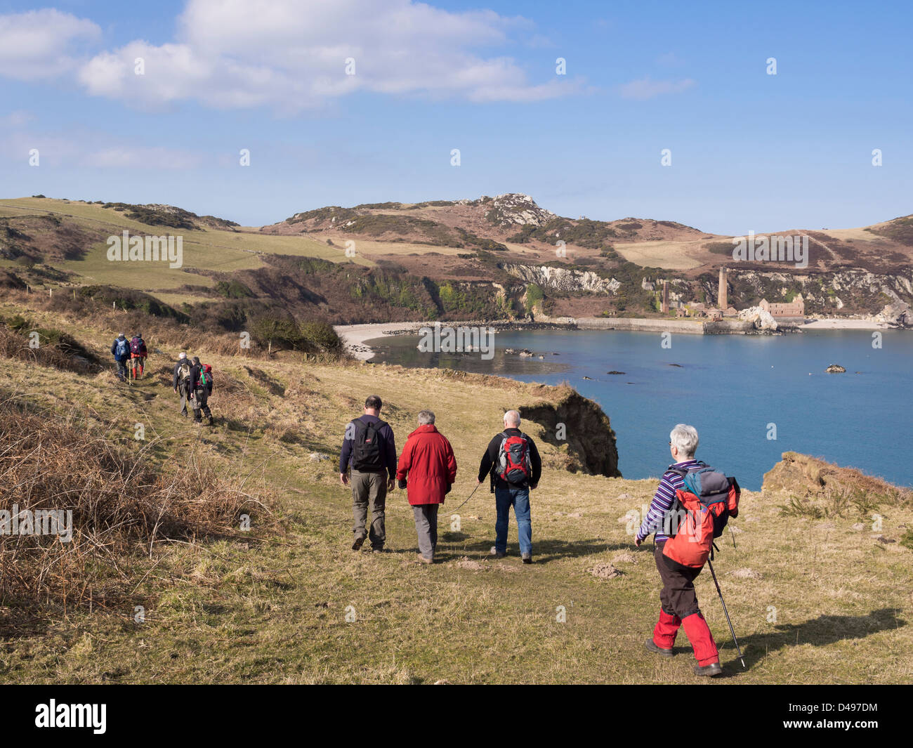 Escursionisti a piedi sull isola di Anglesey sentiero costiero con vista sulla baia di derelitti Porth Wen laterizi. Anglesey, Galles del Nord, Regno Unito Foto Stock
