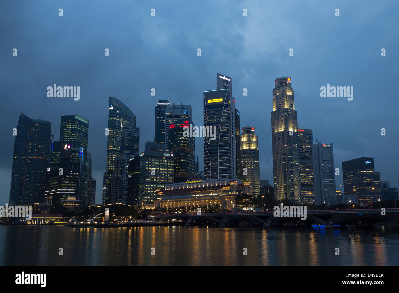 Il Marina Bay a Singapore, 20 febbraio del 2012, il Fullerton hotel e grattacieli della zona commerciale nel crepuscolo Foto Stock