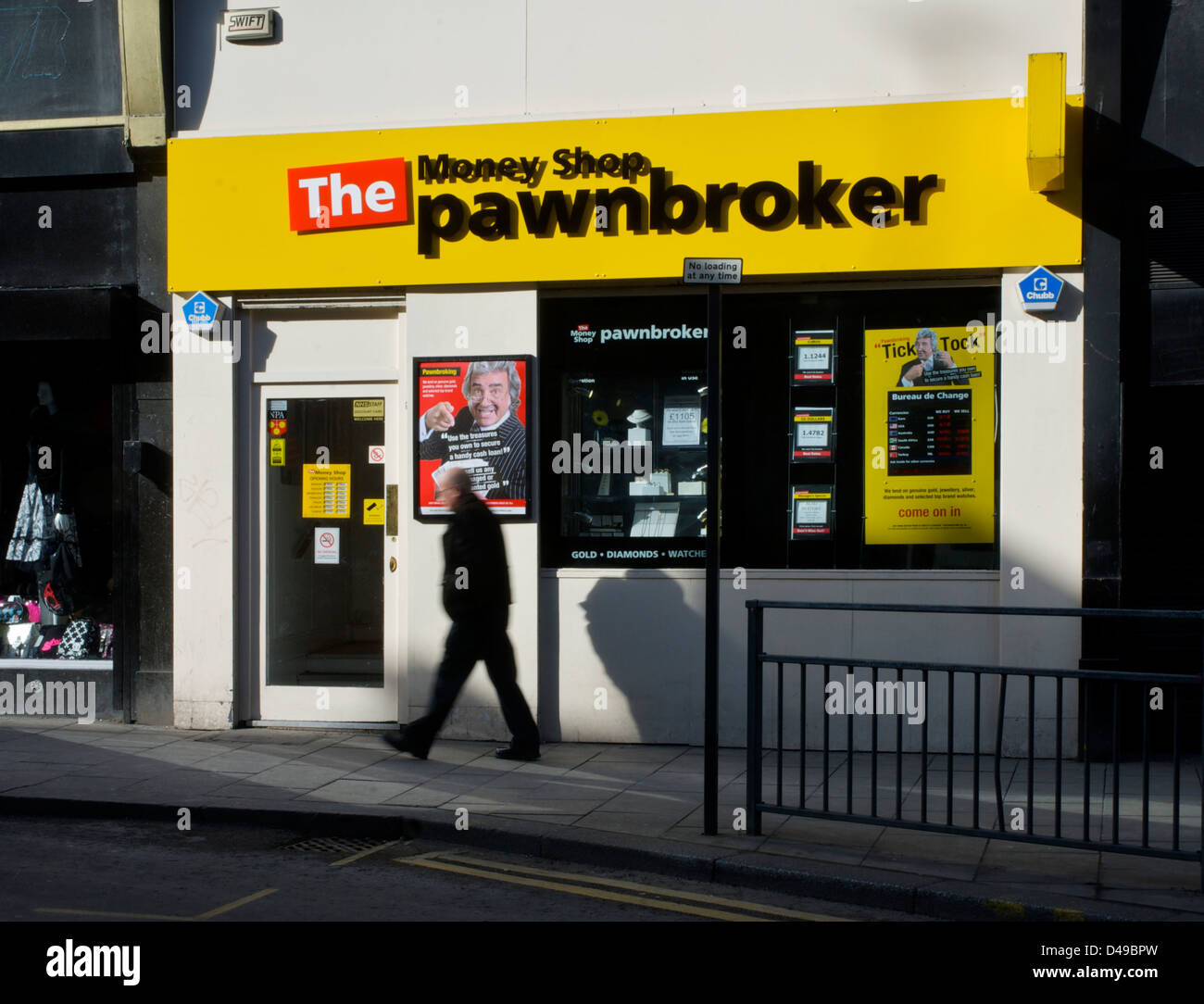 Uomo che cammina passato il denaro Shop Pawnbroker a Leeds, West Yorkshire, Inghilterra, Regno Unito Foto Stock