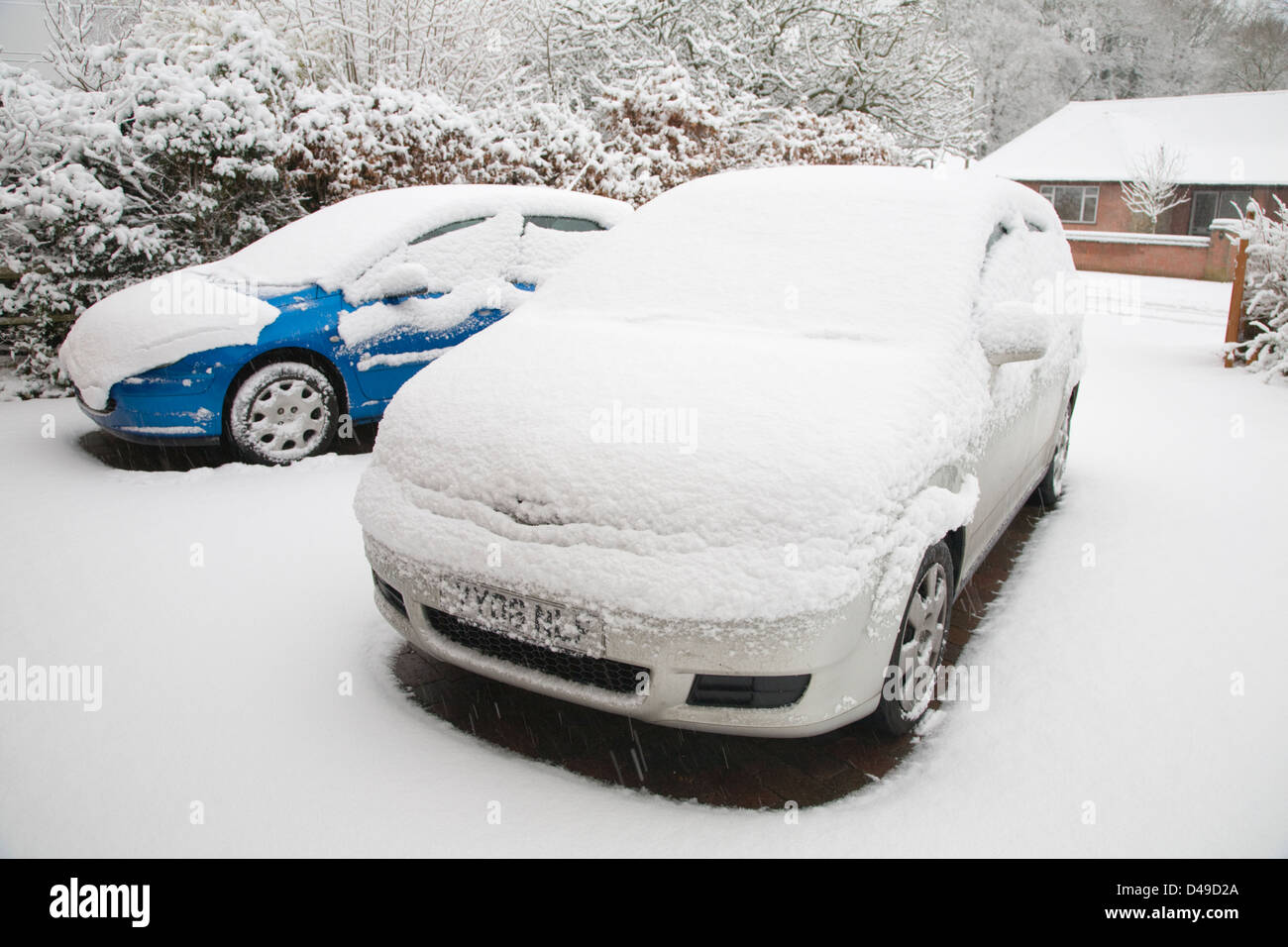 Automobili in un drive ricoperta di neve Foto Stock