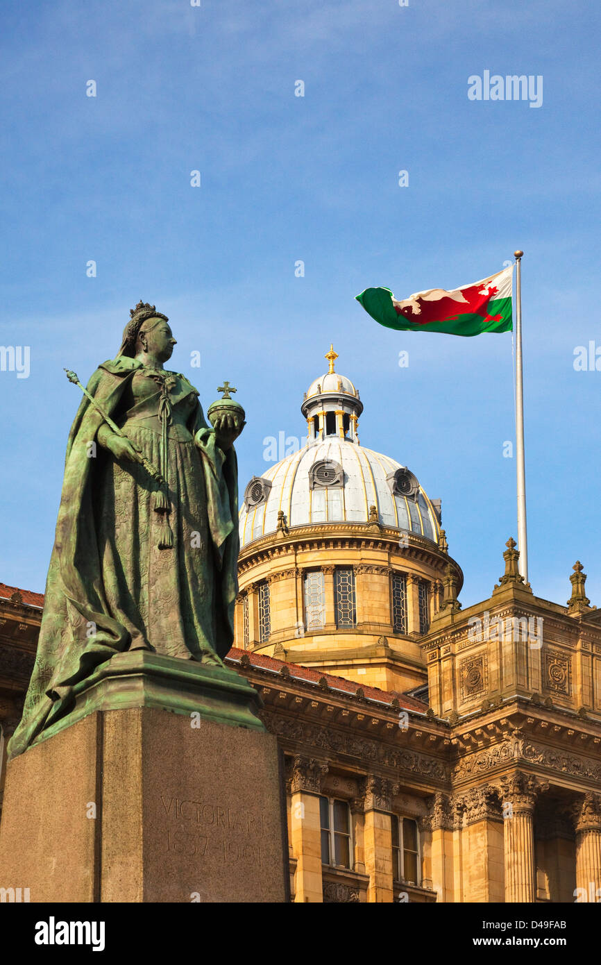 La regina Victoria statua che si trova nella parte anteriore del Birmingham Council House Edificio con gallese battenti bandiera Foto Stock