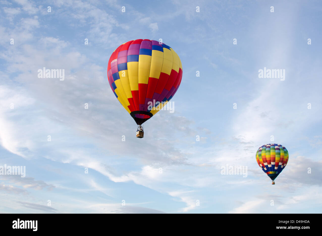 Due i palloni ad aria calda galleggiante attraverso nuvole bianche in un cielo blu. Foto Stock
