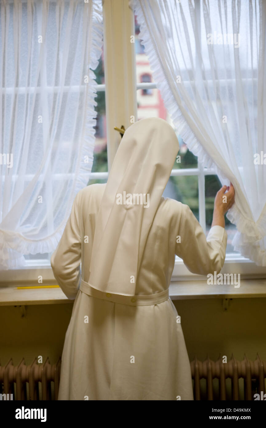 Heitersheim, Germania, una sorella guardando fuori dalla finestra Foto Stock