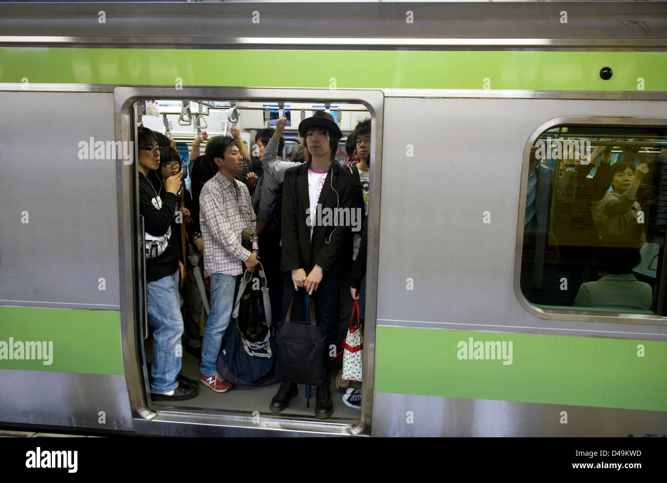 Pendolari in piedi a bordo della Yamanote linea loop treno che gira intorno alla città di Tokyo, Giappone. Foto Stock