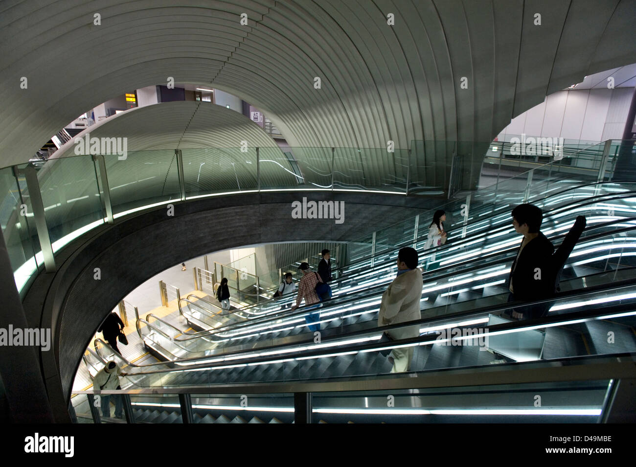 Una moderna architettonica di interni in corrispondenza di una metropolitana escalator pendolari si sposta alla piattaforma del treno in Shibuya, Tokyo. Foto Stock