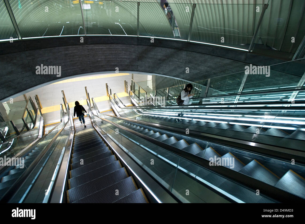 Una moderna architettonica di interni in corrispondenza di una metropolitana escalator pendolari si sposta alla piattaforma del treno in Shibuya, Tokyo. Foto Stock