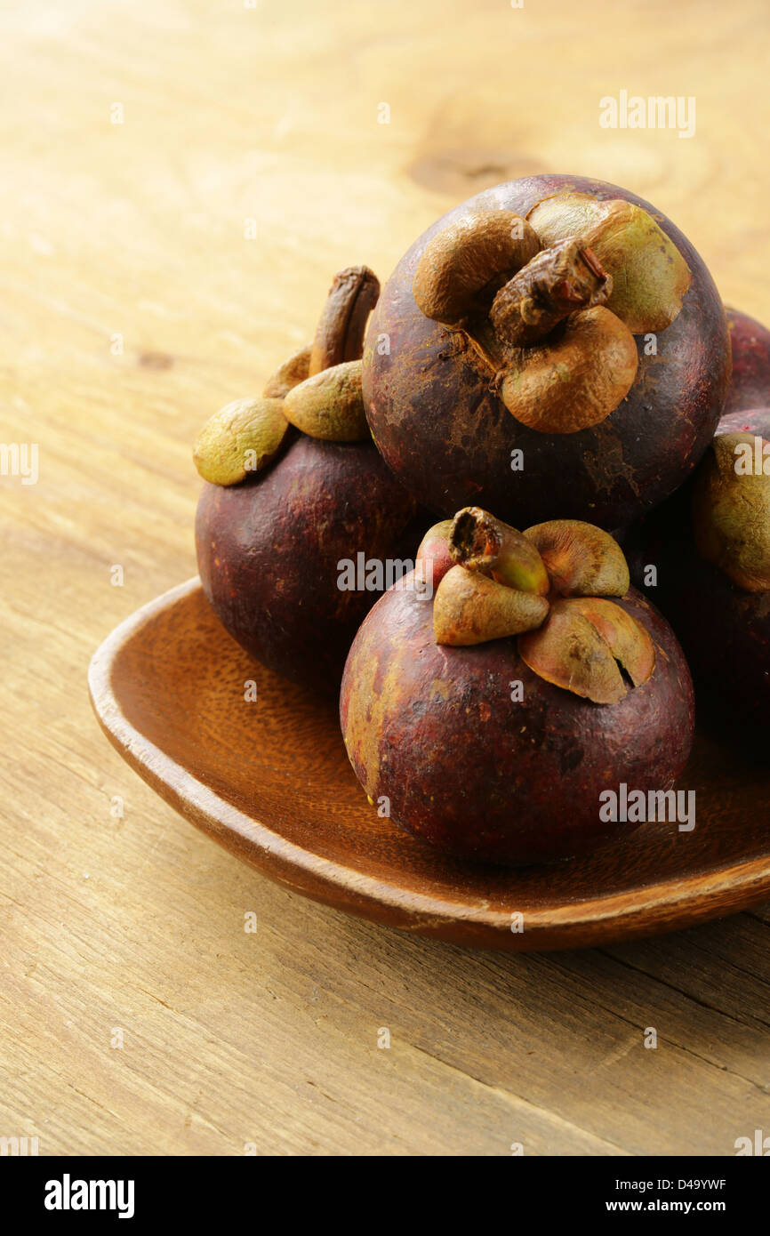 Fresca frutta esotica mangosteen sul piatto di legno Foto Stock