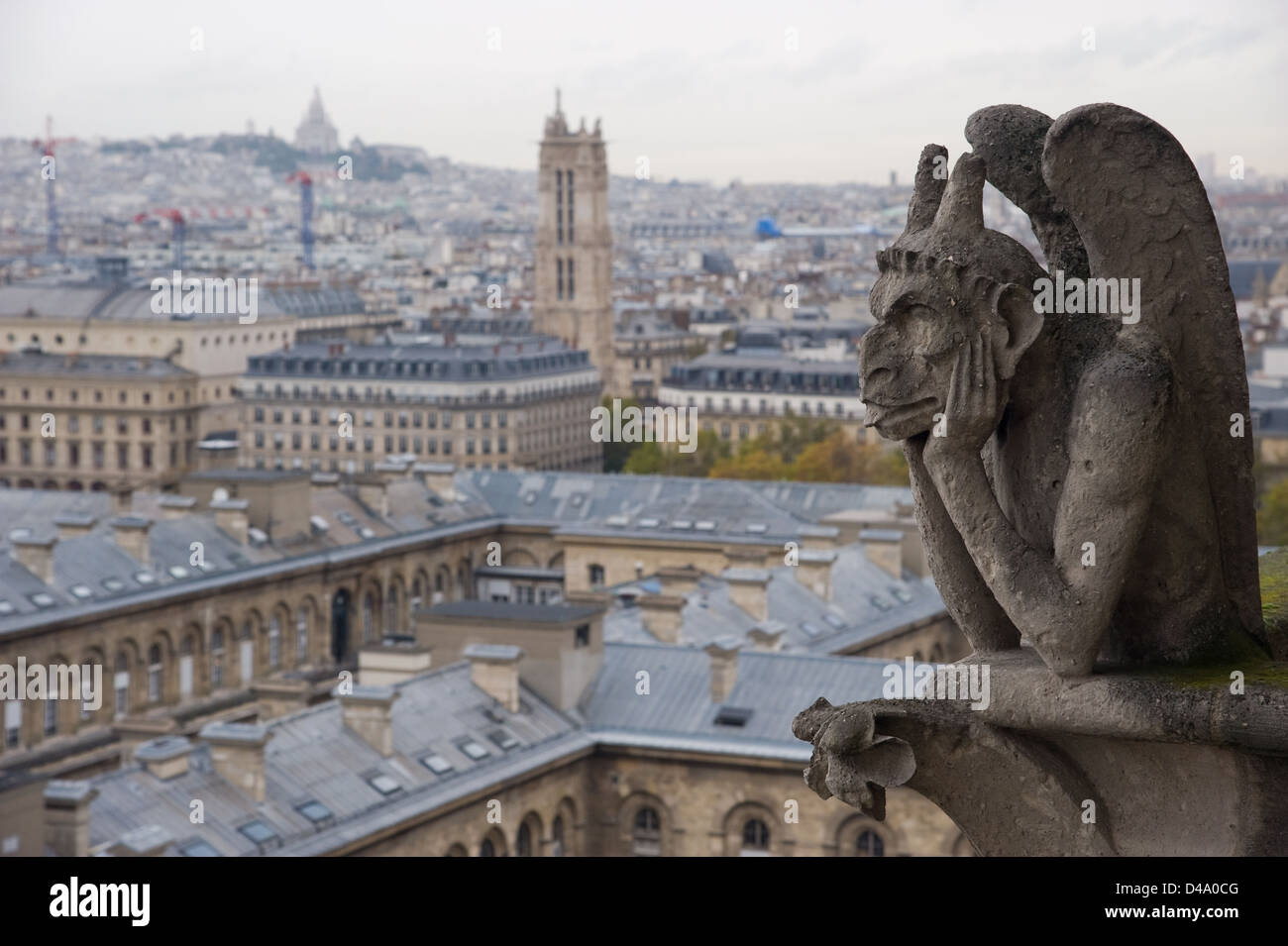 Gargoyle di pietra (Chimera) che si affaccia sulla città di Parigi dalla Torre della cattedrale di Notre Dame con la Basilica del Sacro Cuore in background Foto Stock