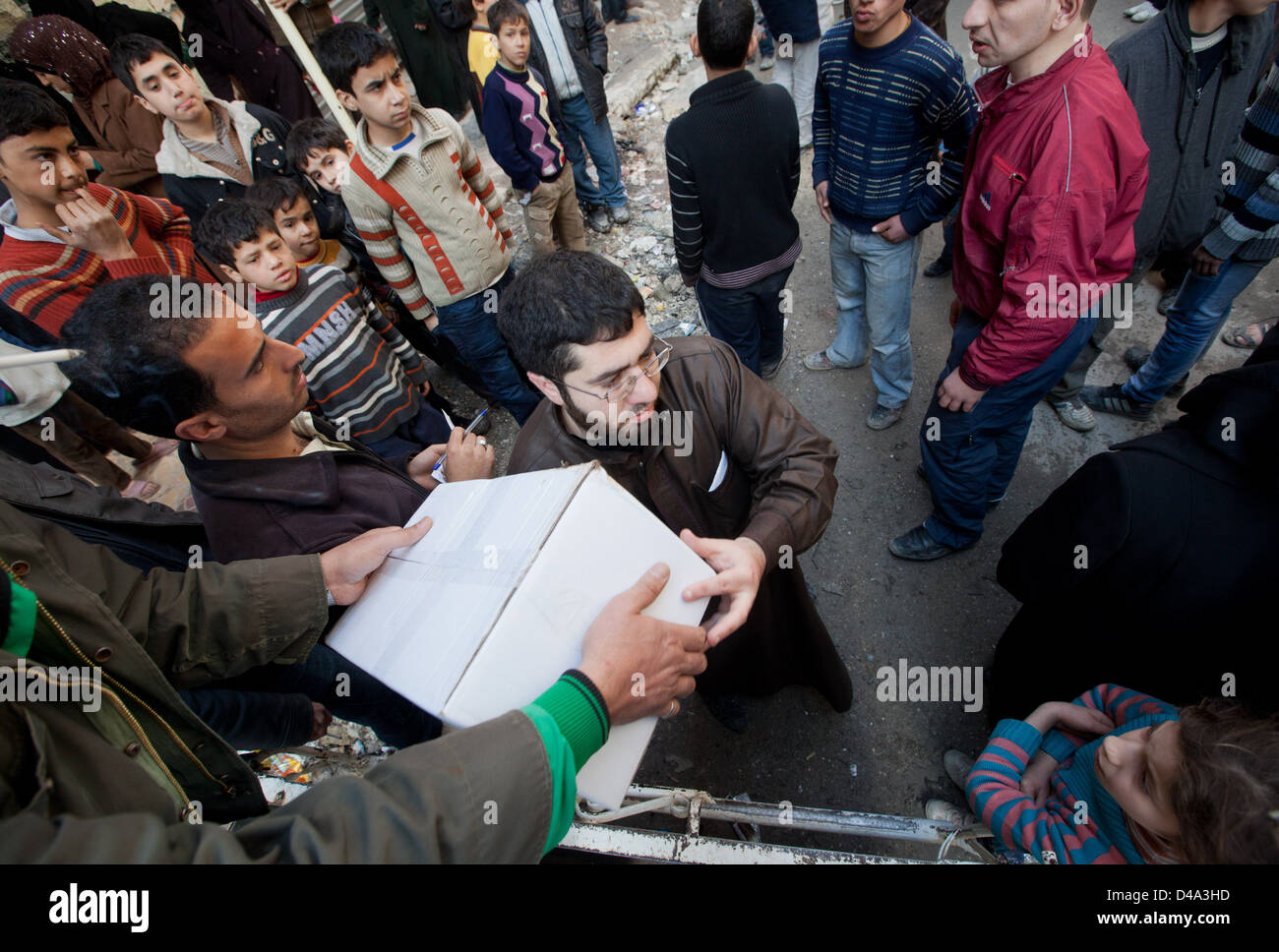 Aleppo, Siria: persone distribuire15kg box di aiuti alimentari alle persone bisognose Bustan Al Qasr sezione di Aleppo, Siria Foto Stock