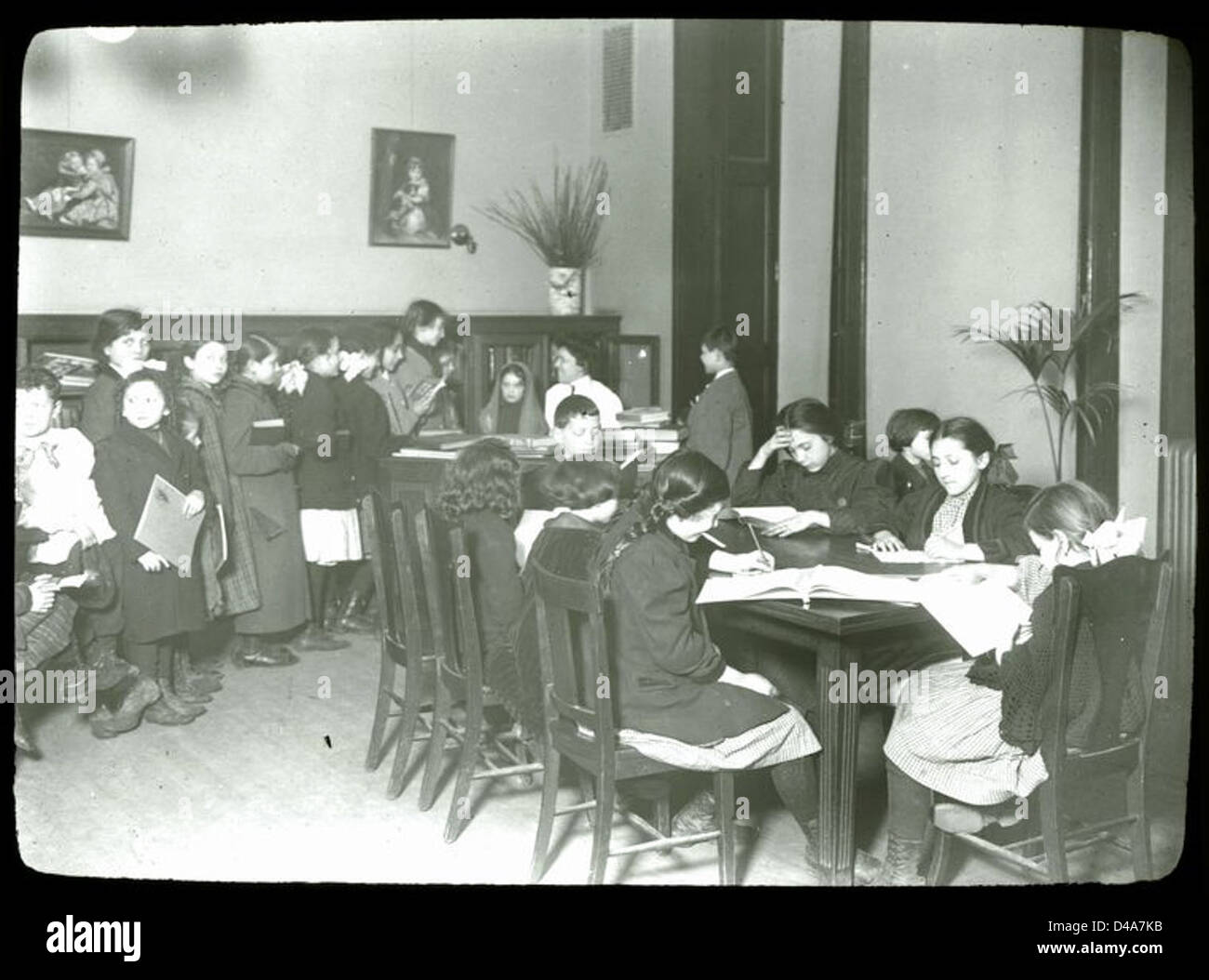 Questa fotografia del 1914 cattura i bambini in attesa del loro turno a un evento di estensione della biblioteca a New York, evidenziando l'importanza dei programmi educativi dei primi anni del XX secolo. Foto Stock