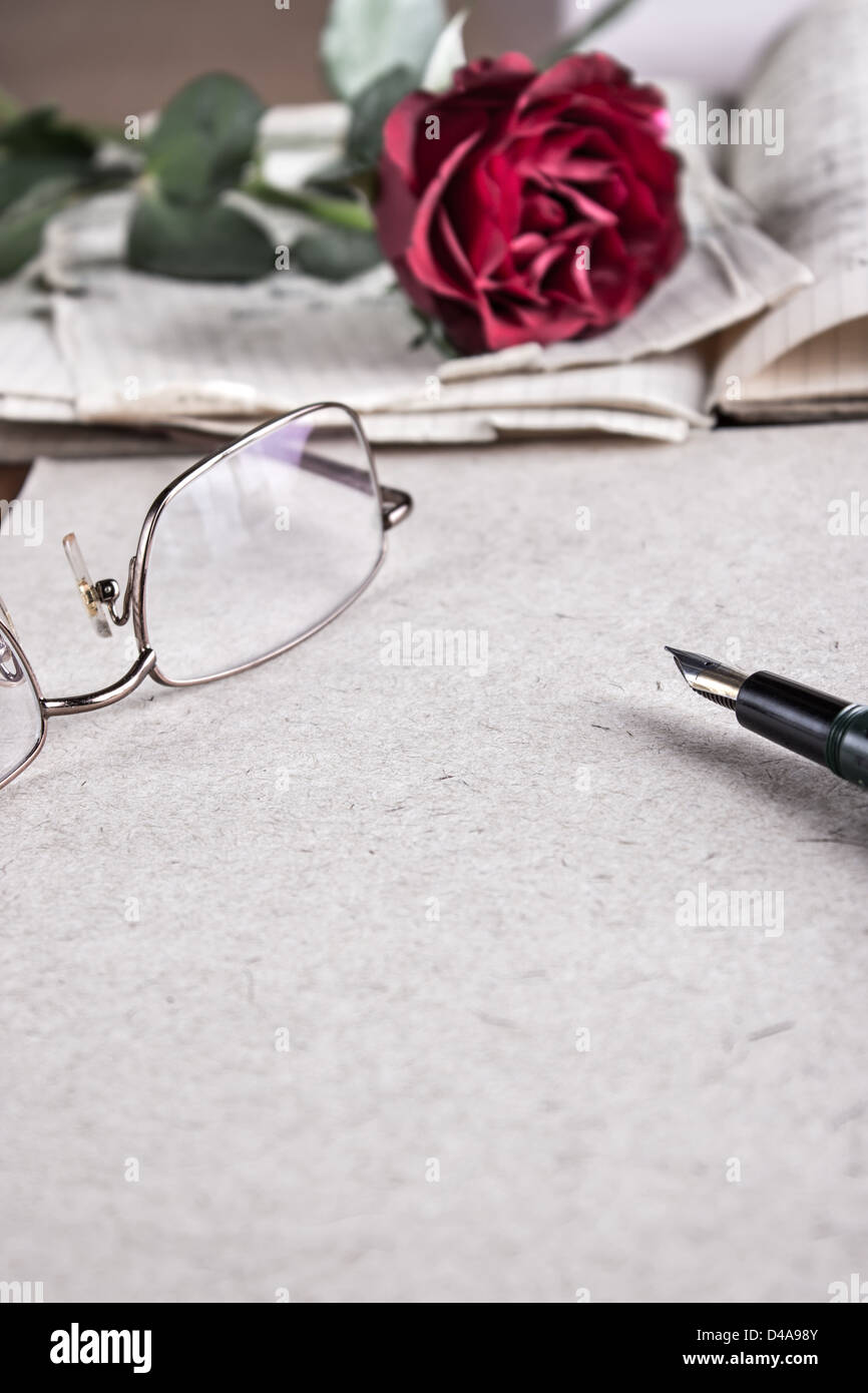 Una rosa rossa sulla vecchia carta.Lettera d'amore Foto Stock