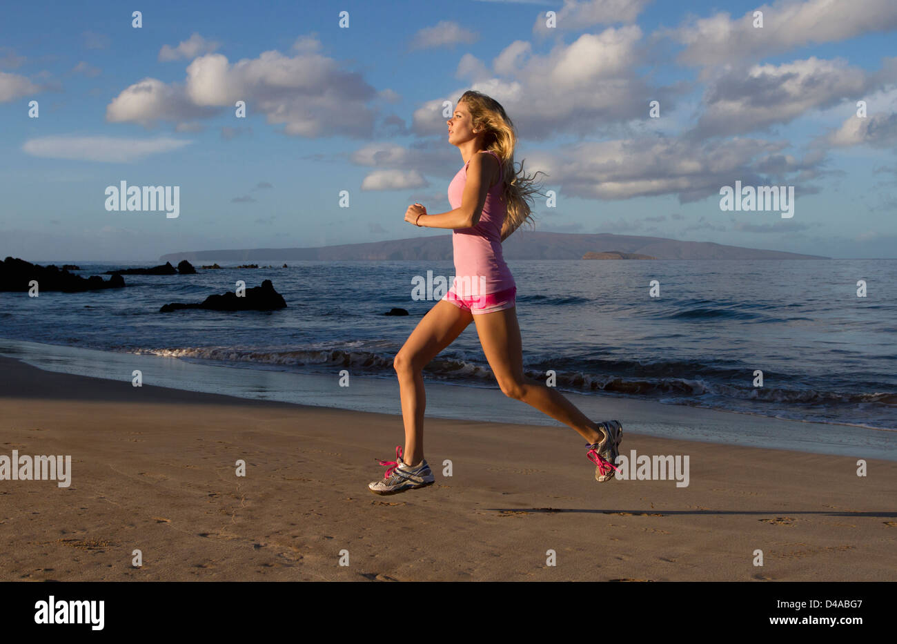 Un sano, montare la donna esercita presso la spiaggia di Wailea, Maui, Hawaii. Foto Stock