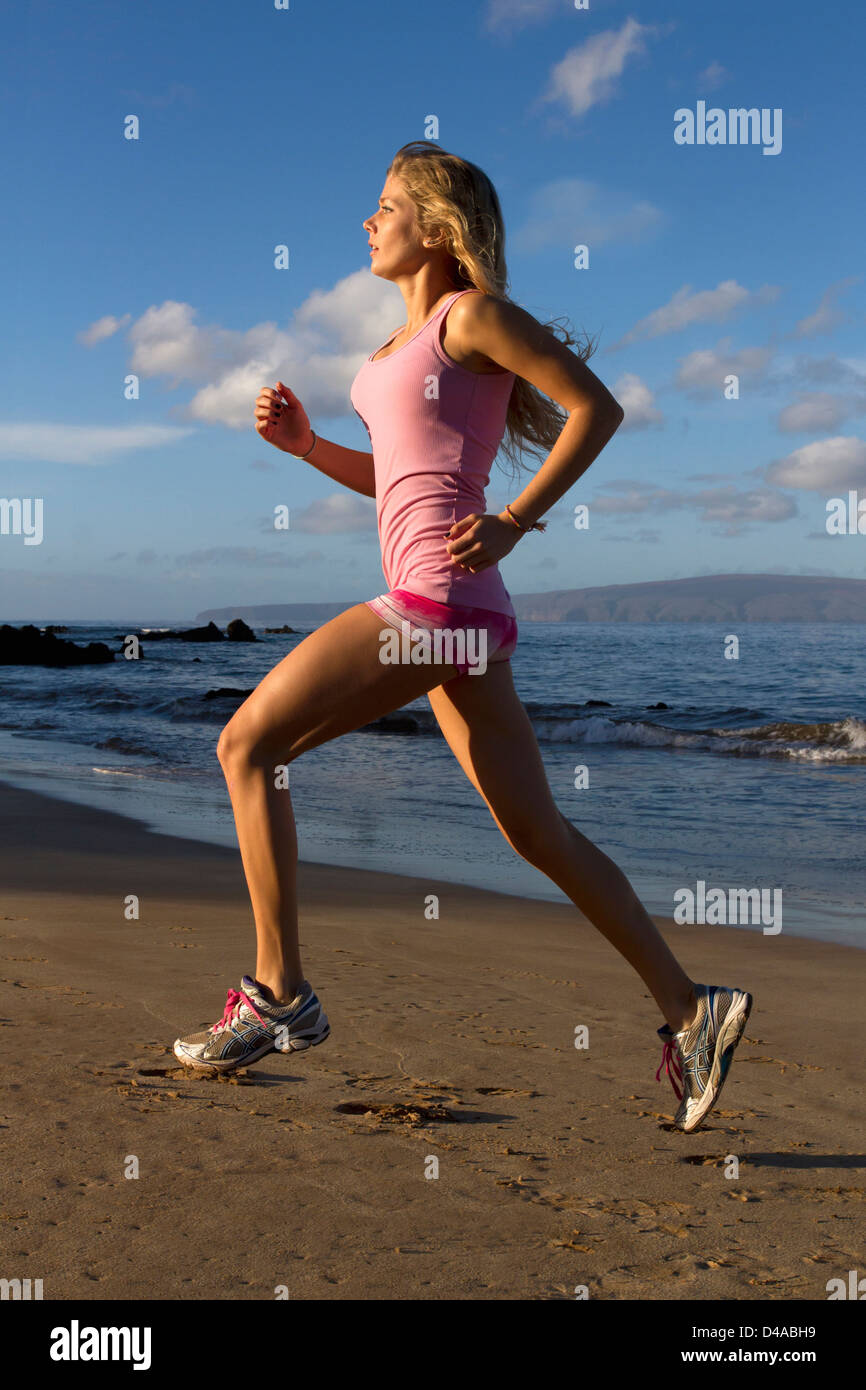 Un sano, montare la donna esercita presso la spiaggia di Wailea, Maui, Hawaii. Foto Stock