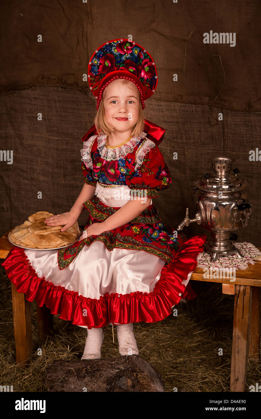 Bella ragazza russa con piastra completa di frittelle pronto a mangiare frittelle Foto Stock