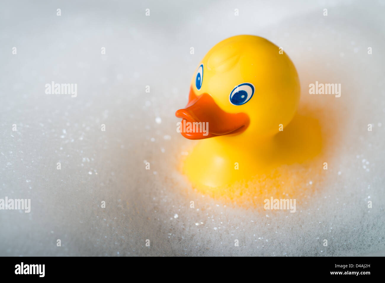 Gomma gialla anatra in una vasca da bagno circondato da bolle Foto Stock