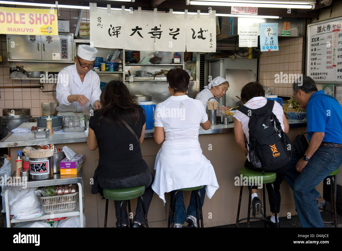 Tutti e quattro i sedili occupati in corrispondenza di una prima colazione a base di noodle soup diner vicino a Tsukiji Commercio all'ingrosso Mercato del Pesce a Tokyo in Giappone Foto Stock