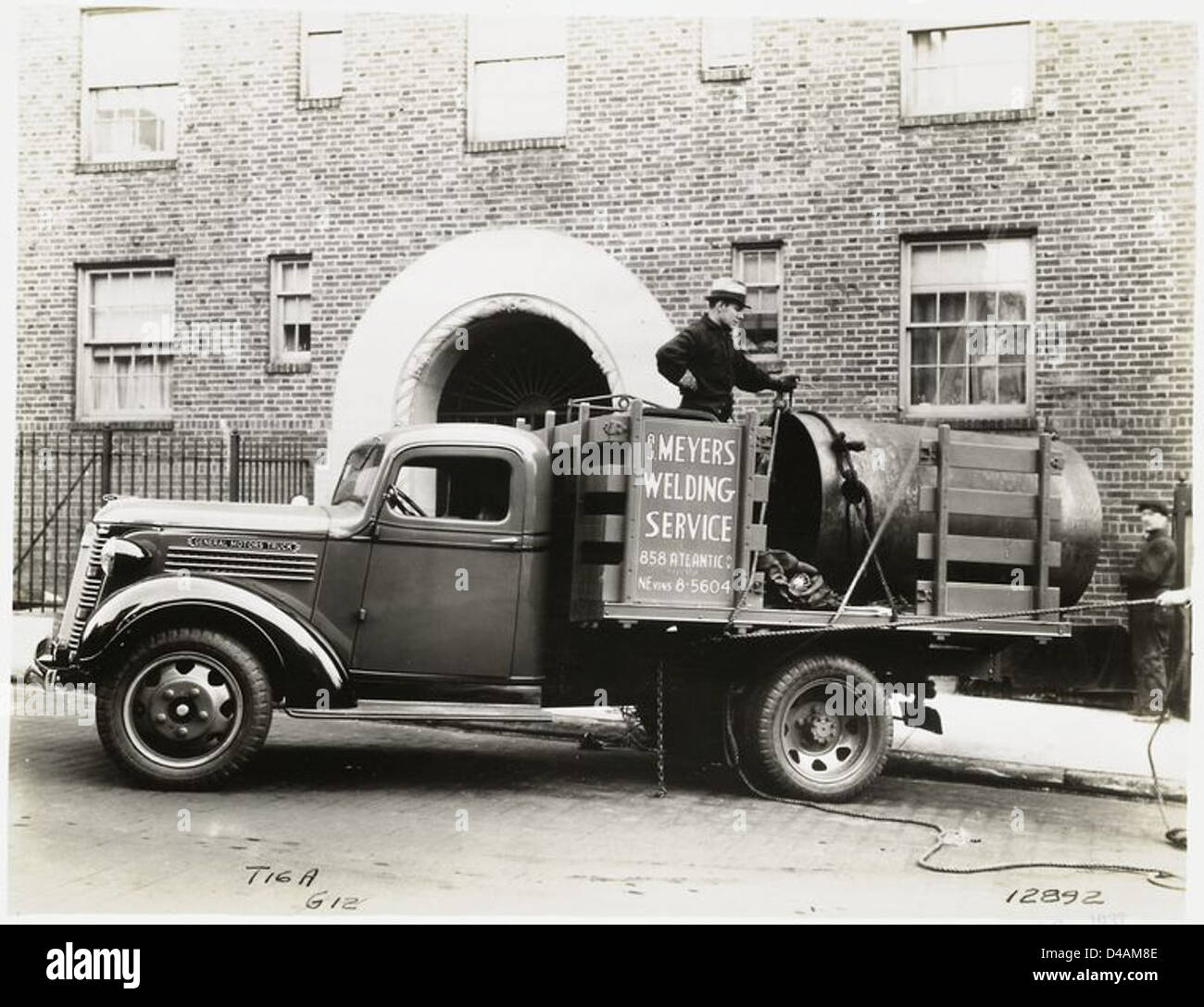 Questa immagine del 1938 mostra i lavoratori che utilizzano un veicolo Model T per A.C. me, che rappresenta l'evoluzione dei veicoli commerciali nel settore automobilistico all'inizio del XX secolo. Foto Stock