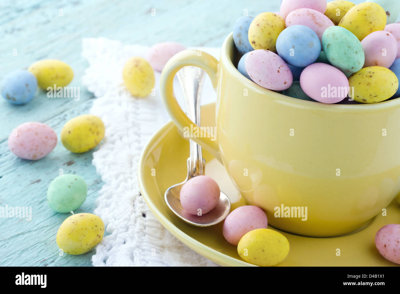 Uova di Pasqua in una tazza di colore giallo sul legno sfondo vintage Foto Stock