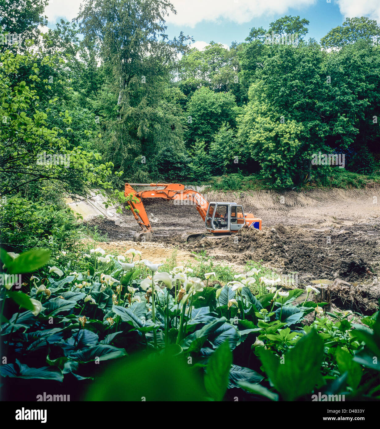 La pala di scavare un laghetto in giardino Bretagna Francia Foto Stock