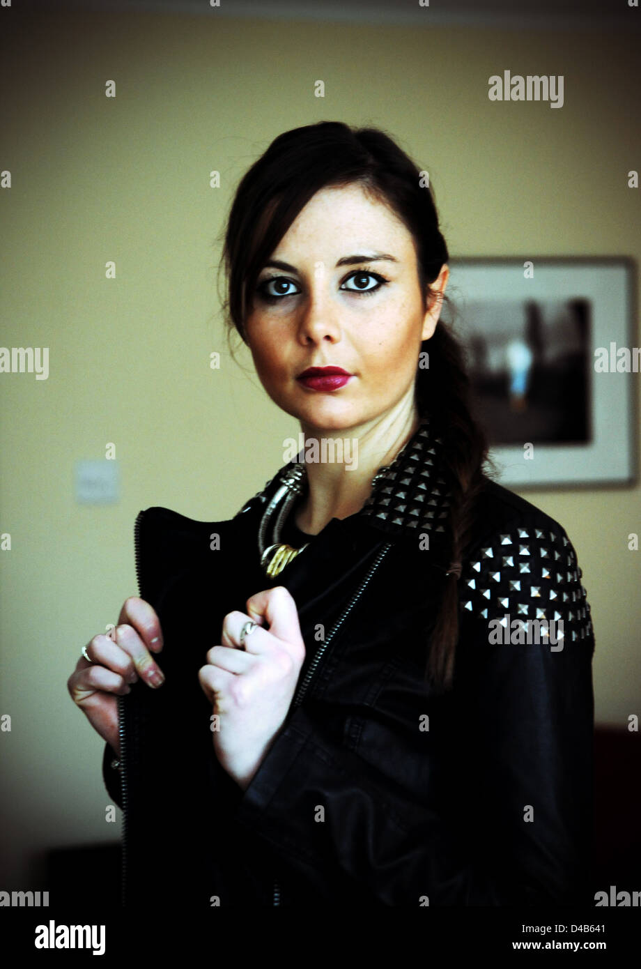 Giovane donna 20s indossando un costellata giacca di pelle in rock chick stile fashion con capelli spazzate indietro Foto Stock